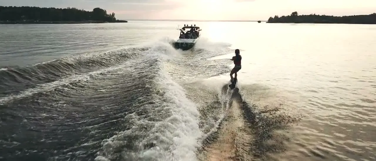An aerial view of a boat cruising on the water on a sunny day